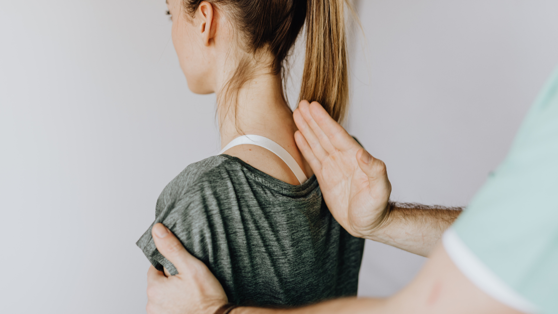 A man using his hand to demonstrate how a posture corrector helps a woman maintain proper posture